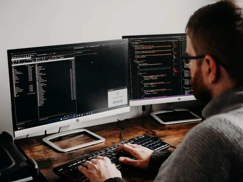 Développeur devant plusieurs écrans de code
