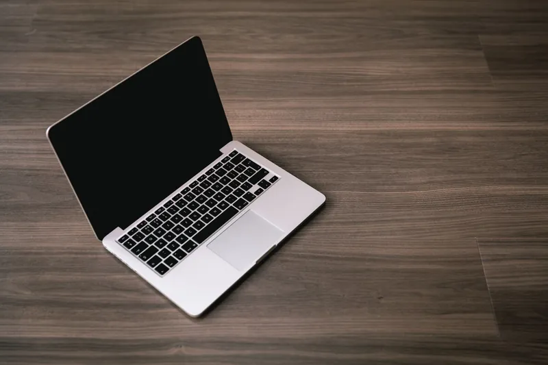 MacBook ouvert sur un bureau en bois