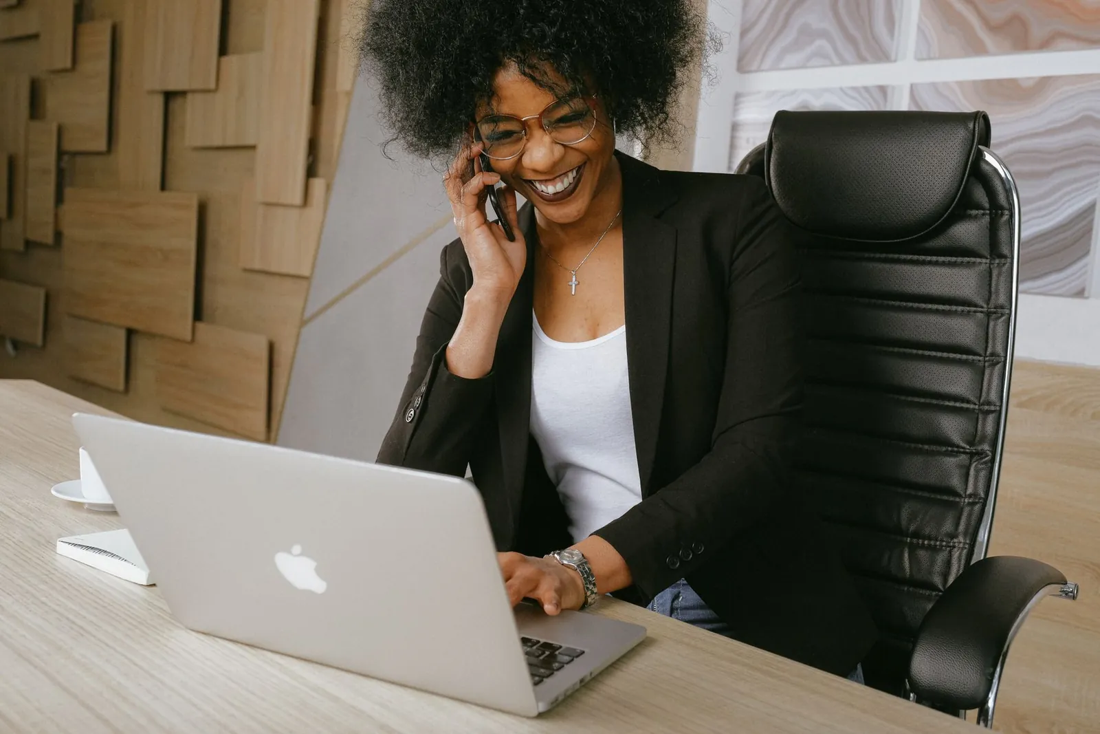 Salariée souriante au téléphone devant son ordinateur