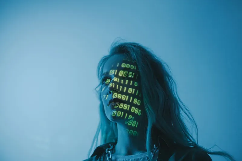 Femme éclairée par du code binaire